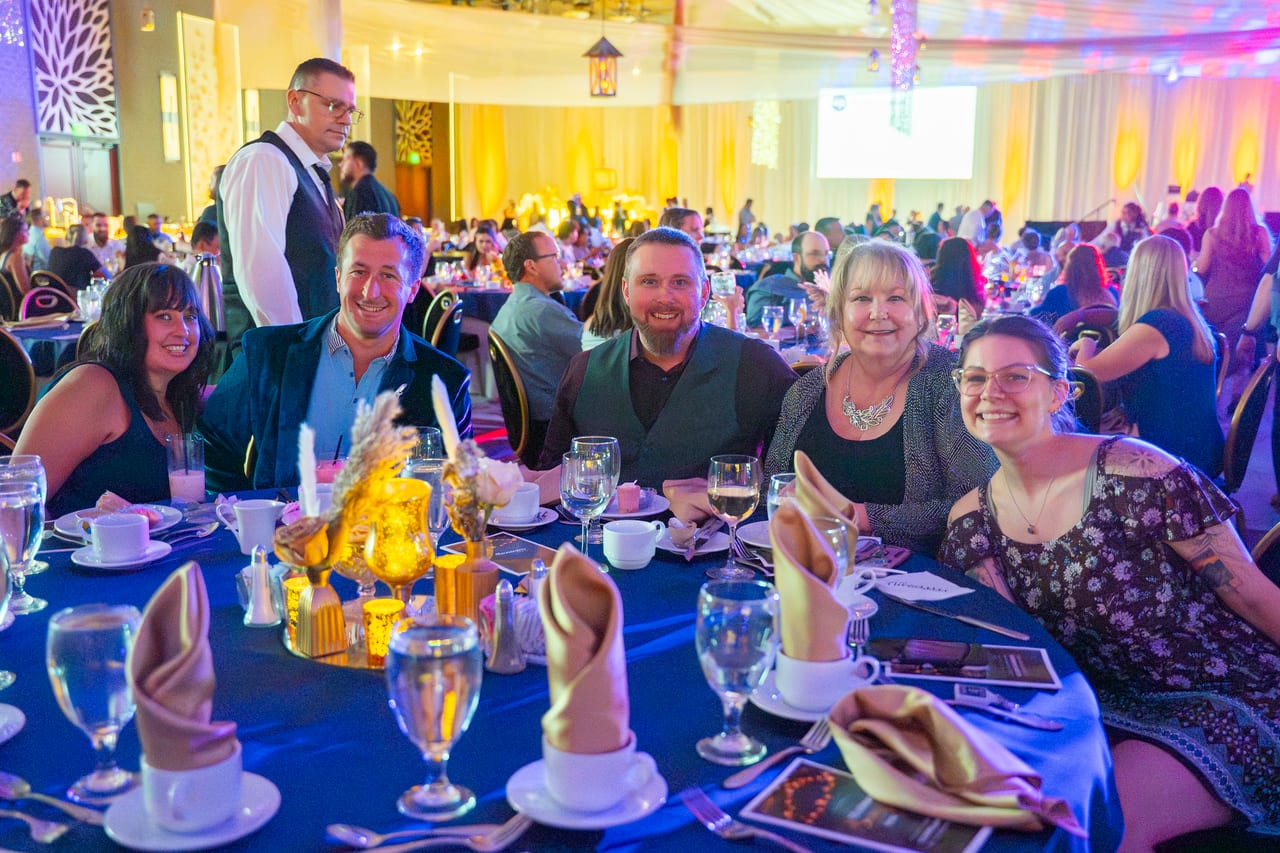 Renown tablemates turning to smile for the camera during dinner