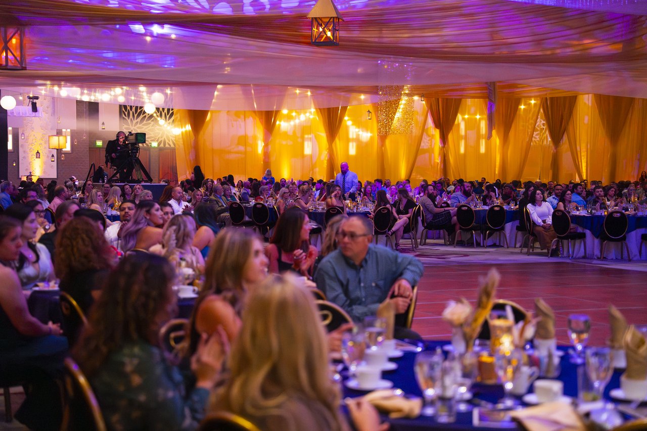 Renown tables applauding under the gold lights