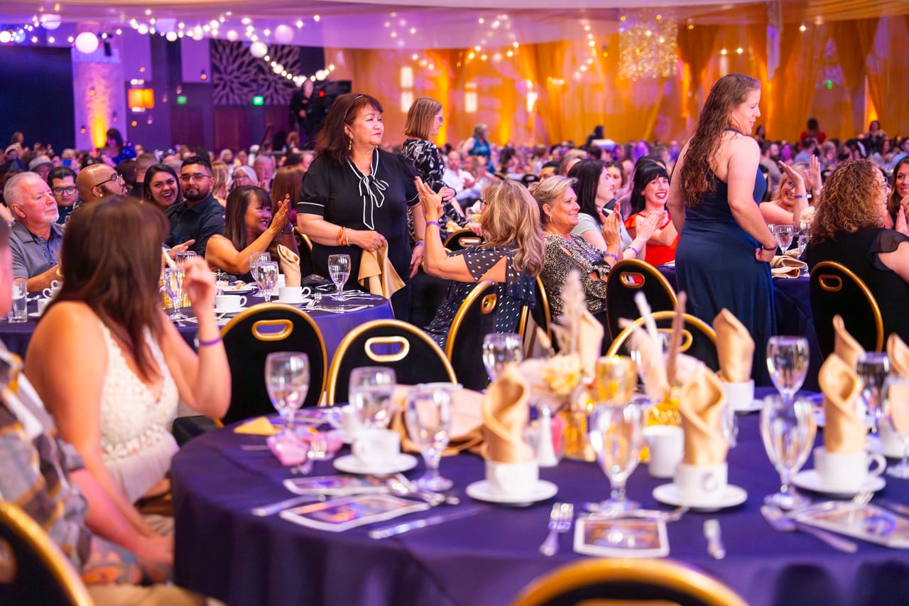 Renown tables cheering as an honoree stands up from her seat