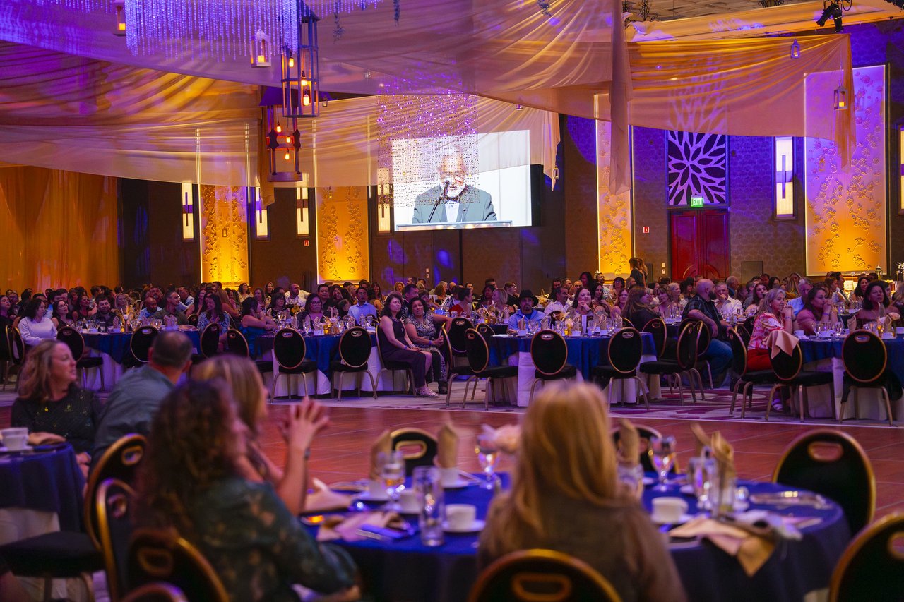 Renown tables clapping for a speaker on the screen