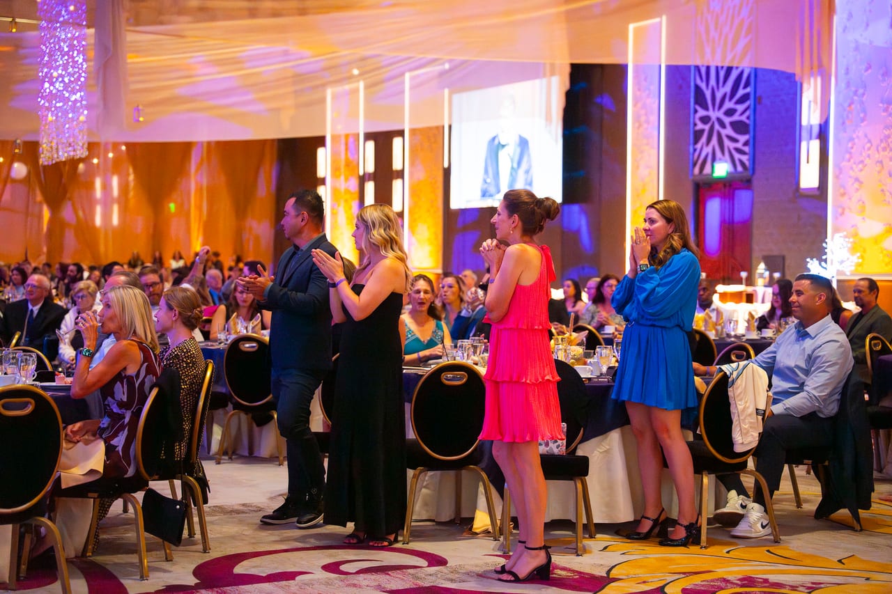 Renown tables standing up to cheer for an honoree