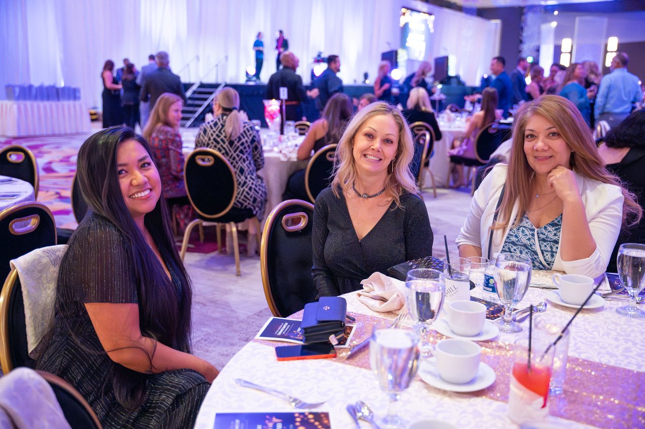 Three Renown coworkers smiling at their table before dinner
