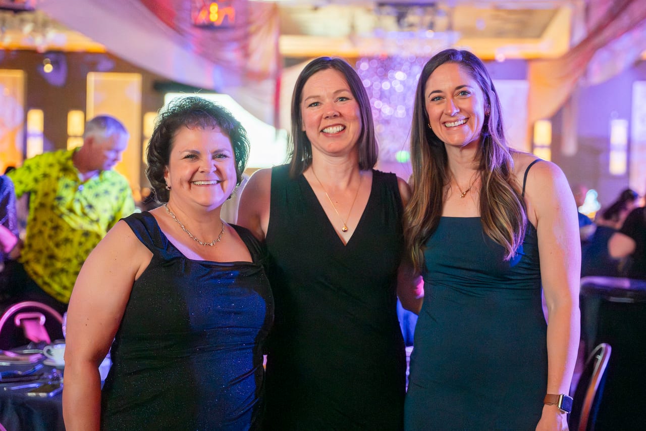 Three Renown friends smiling together in the ballroom