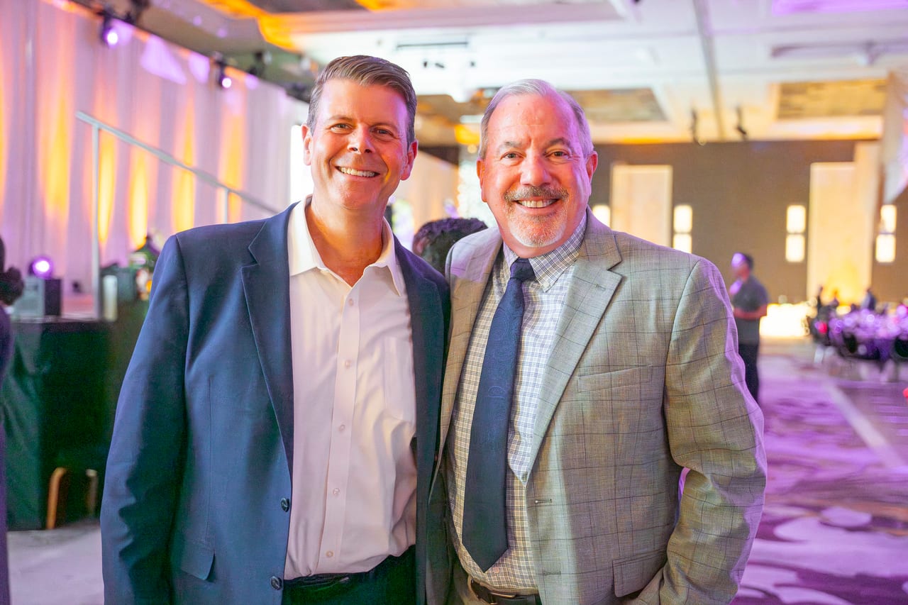 Two Renown coworkers in sport coats smiling in the ballroom
