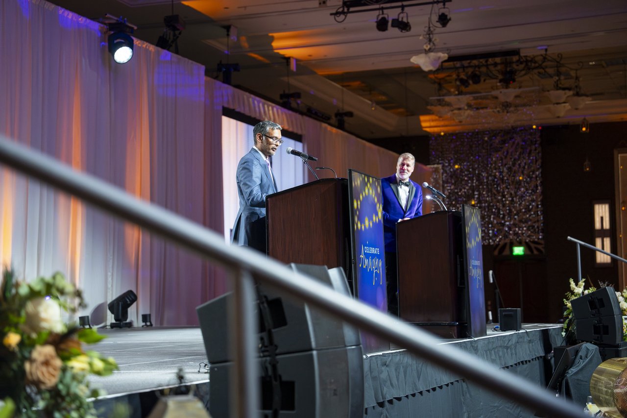 Two speakers at the podiums seen from the stage stairs