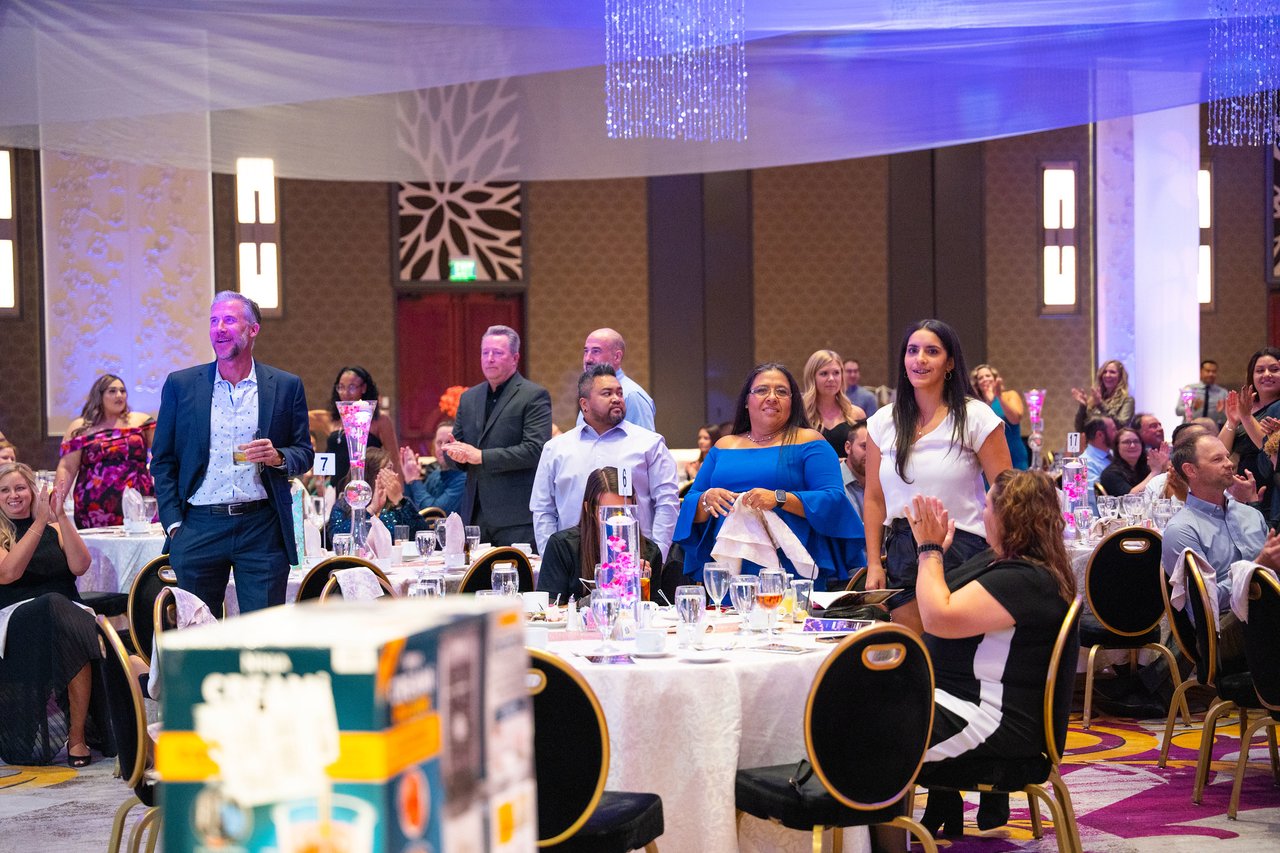 A table of Renown guests standing up to cheer
