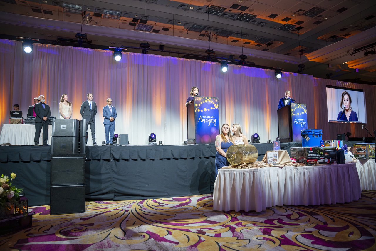 Wide view of the stage, the honorees and the raffle prizes
