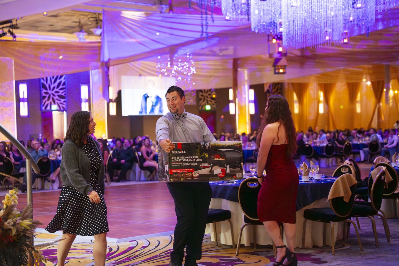 A Renown guest carrying his raffle prize across the dance floor