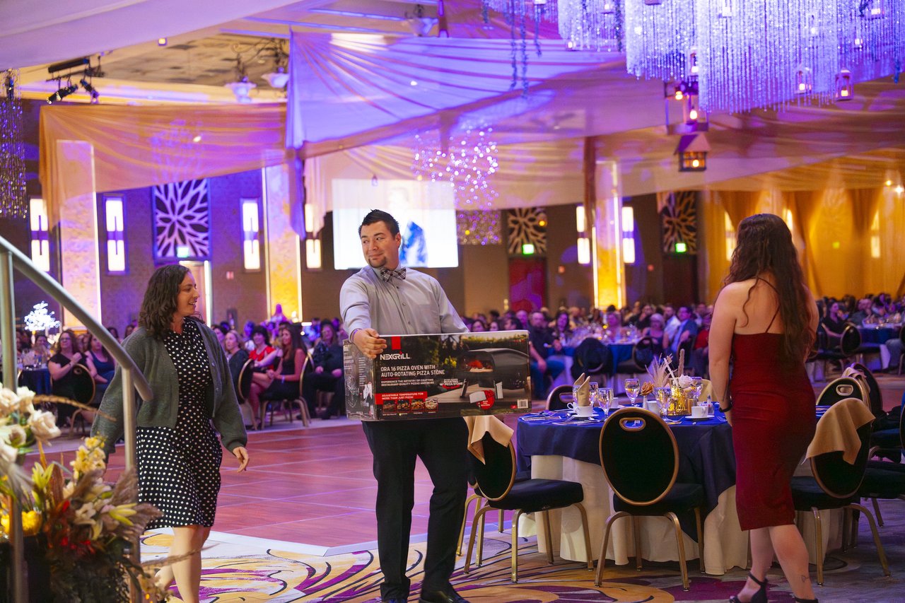 A Renown guest carrying his boxed raffle prize back to his table