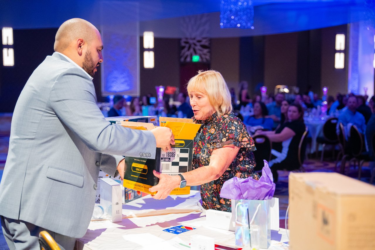 A Renown guest receiving a boxed raffle prize
