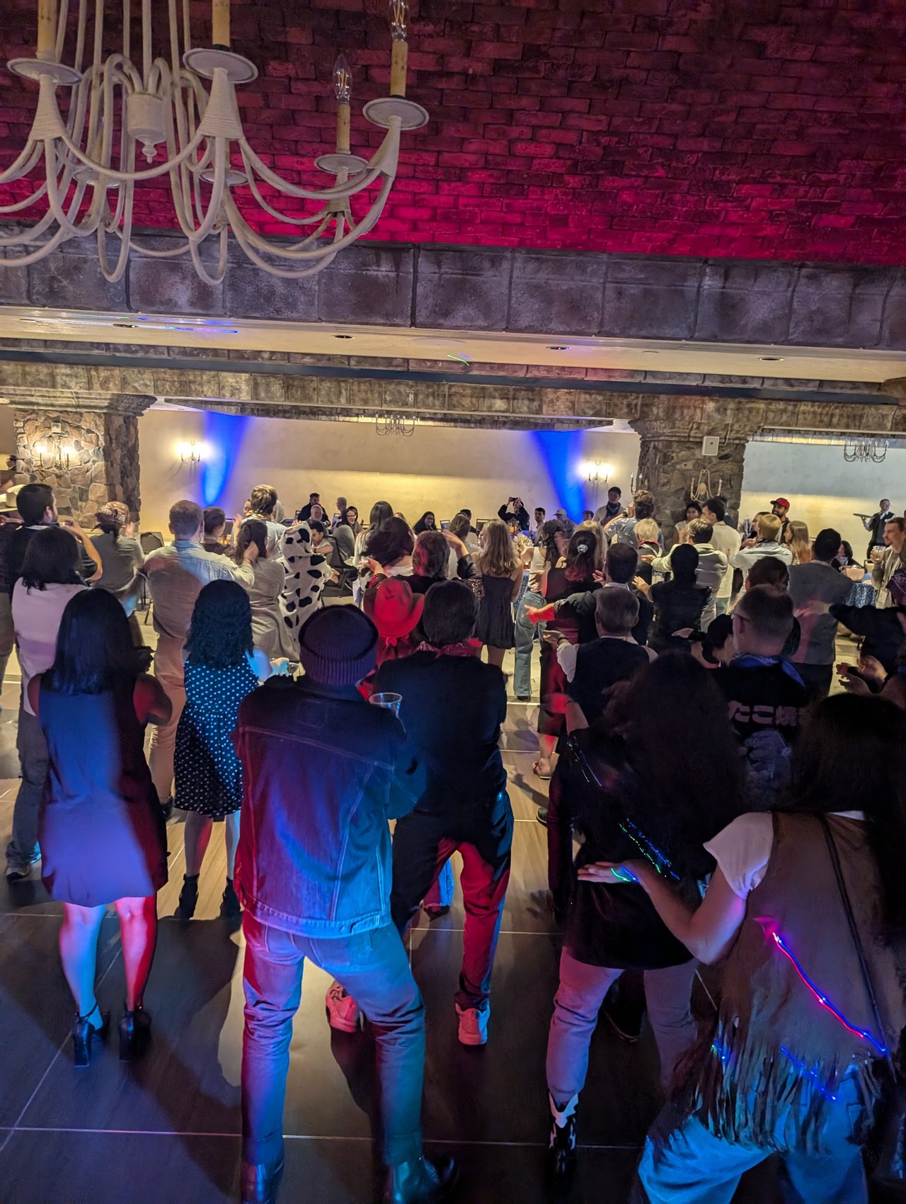 A packed dance floor in hats and plaid