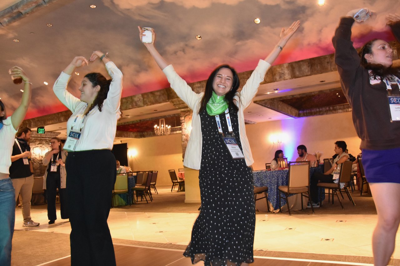 SciX Gala guests dancing with their arms up in the middle of the floor