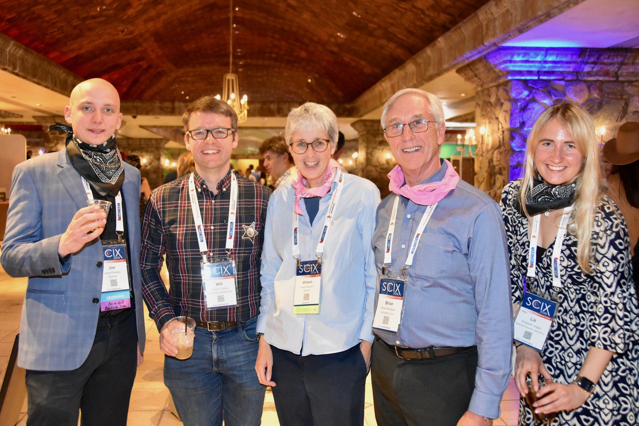 Five guests with bandanas posing in the ballroom