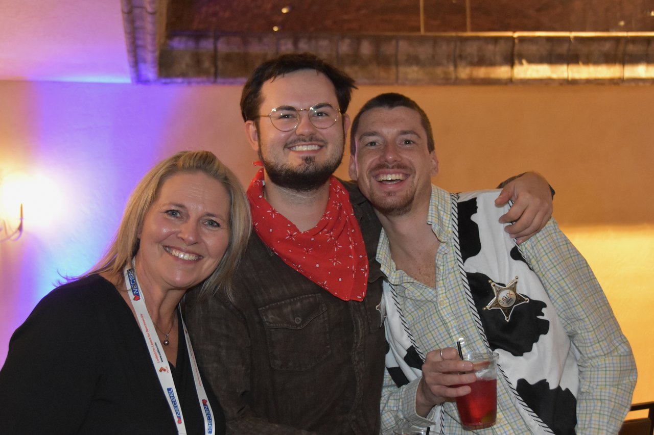 Three friends in bandanas and cow print smiling at the SciX Gala
