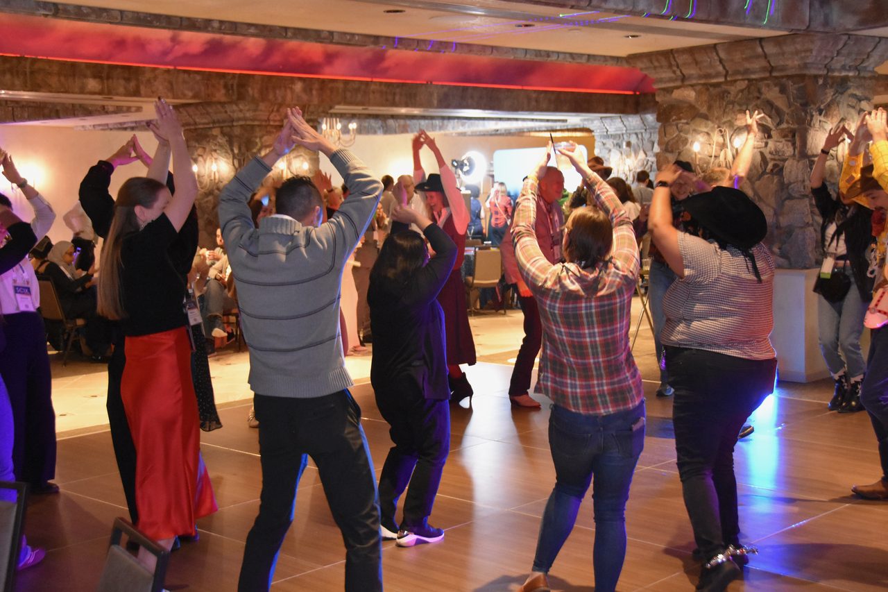 A full dance floor with arms raised at the SciX Gala 2026