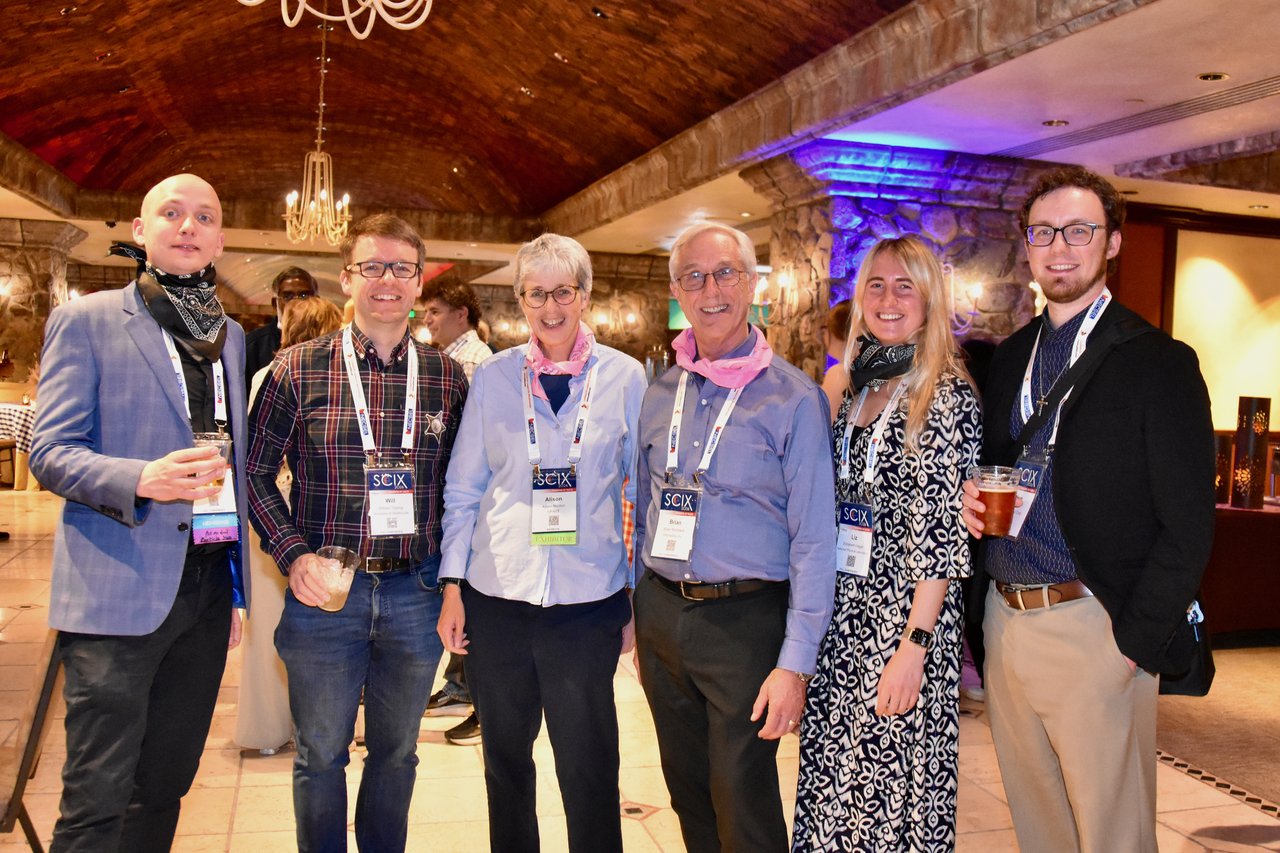 A group of SciX Gala guests in bandanas posing in the ballroom