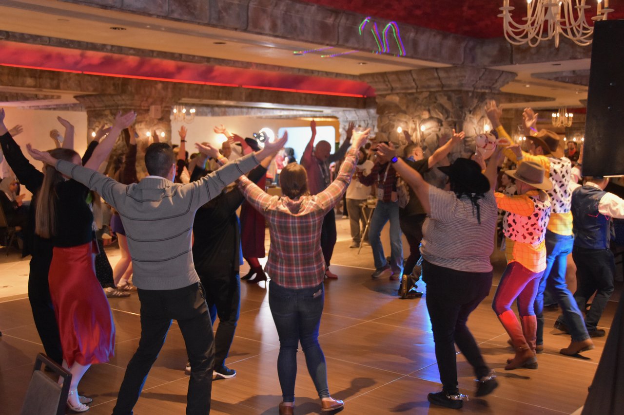 Guests line dancing with their arms up