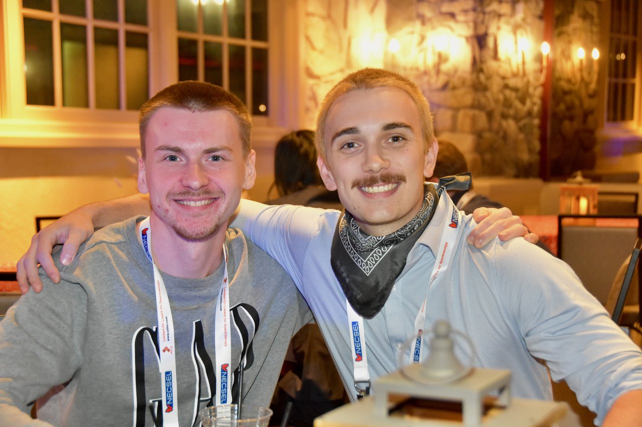 Two friends smiling arm in arm at the SciX Gala