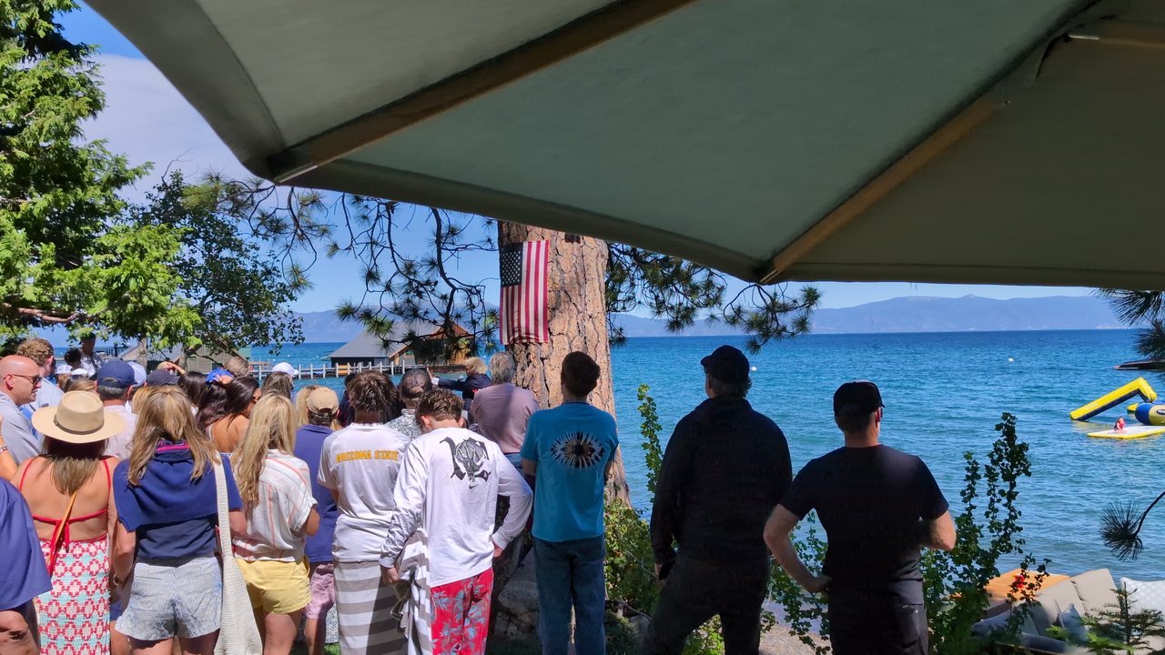 The crowd watching from the lawn, the yellow water slide out on the lake