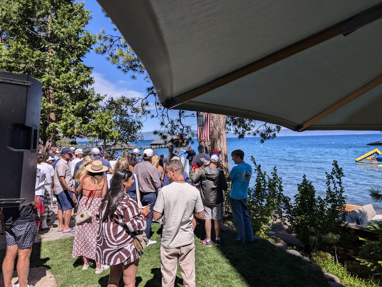 Guests along the shore under the pine, the yellow water slide on the lake
