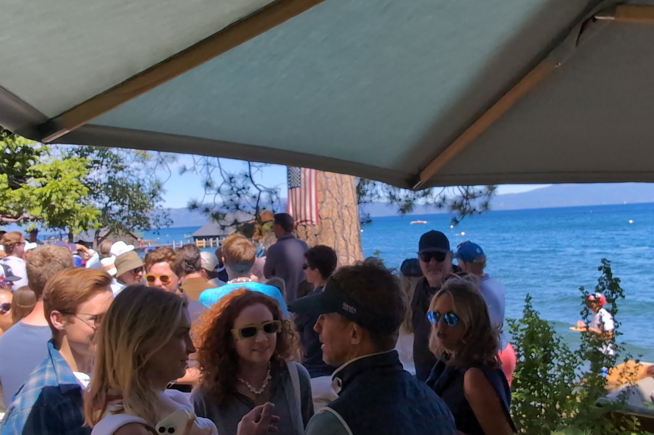 Guests in sunglasses mingling on the lawn by Lake Tahoe