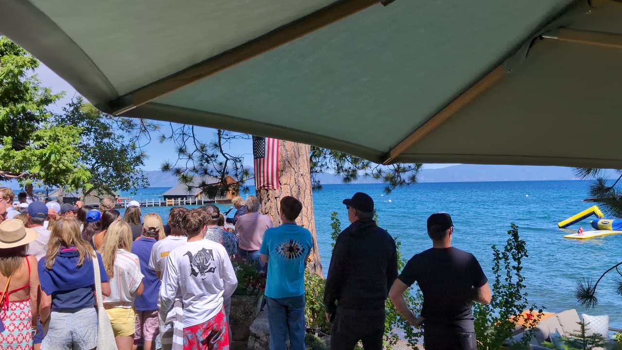 Guests packed along the shore under the patio umbrella
