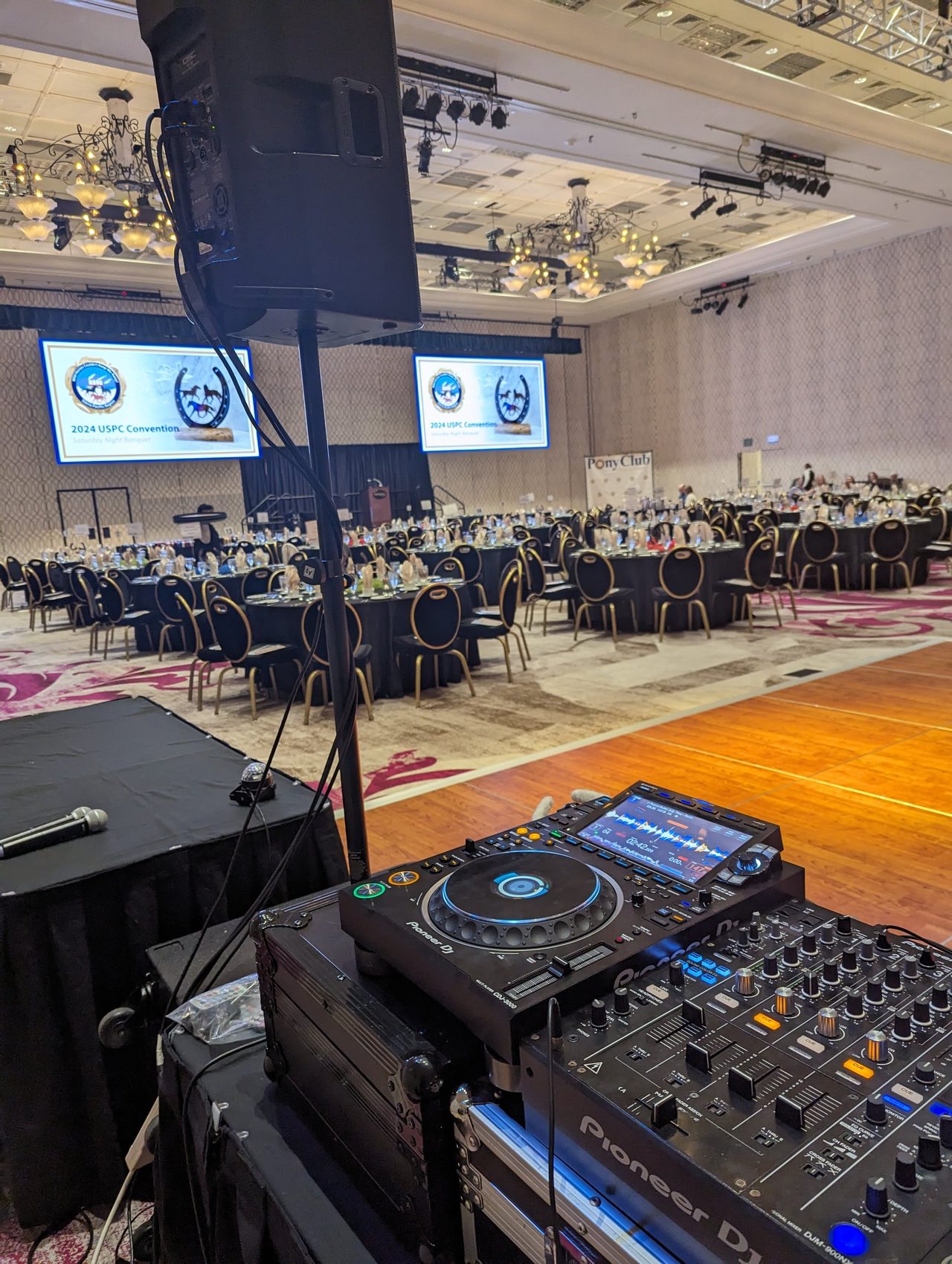 The DJ booth and the banquet room before the doors opened, with the 2024 USPC Convention on the screens