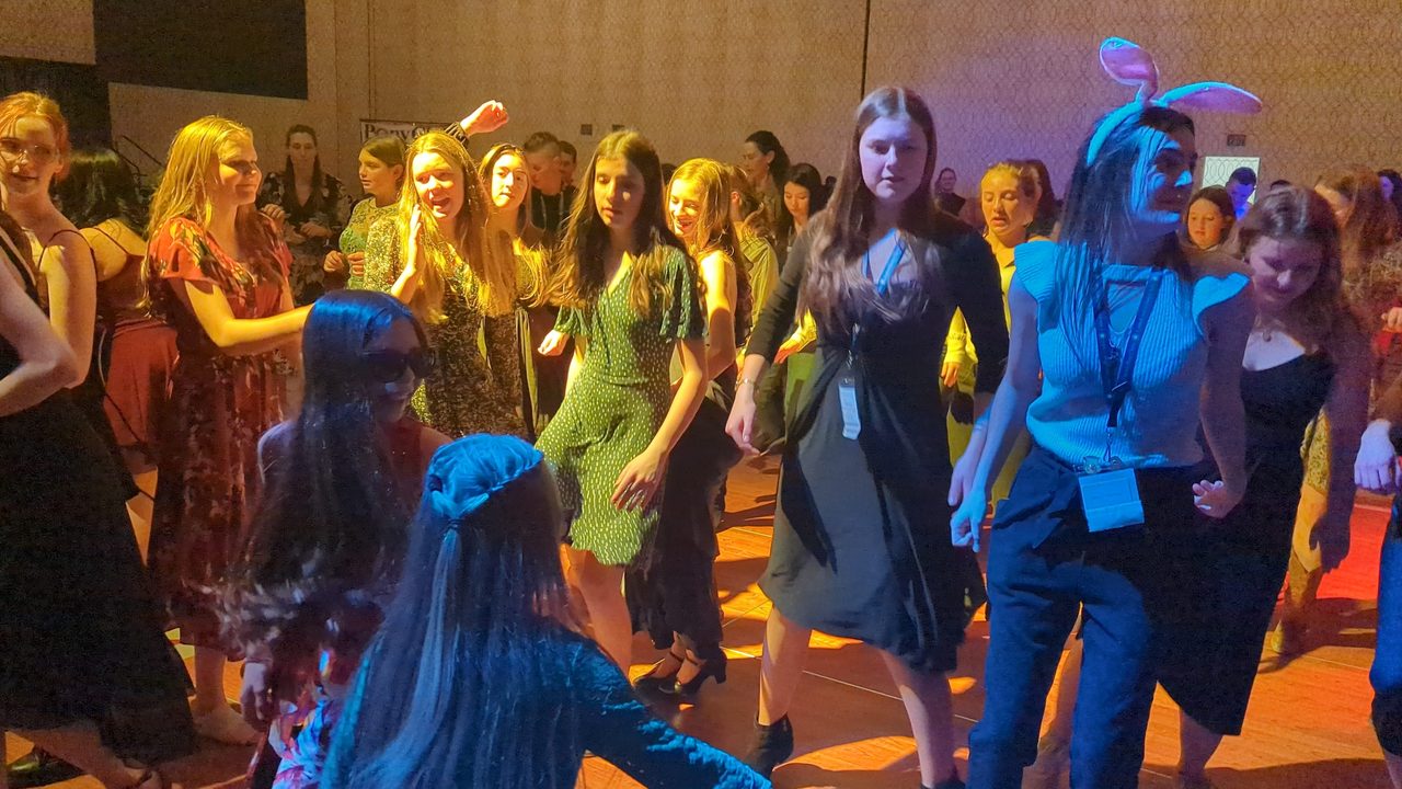 Pony Club members dancing on the floor, one of them in bunny ears