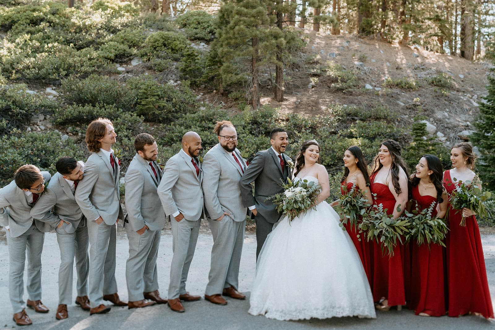 Full bridal party portrait outdoors with groomsmen in gray suits and bridesmaids in red dresses - DJs In Reno wedding
