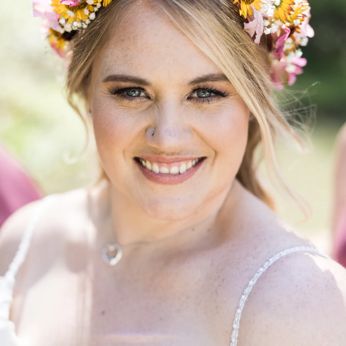 Abney smiles straight into the camera in a close portrait, wearing her flower crown