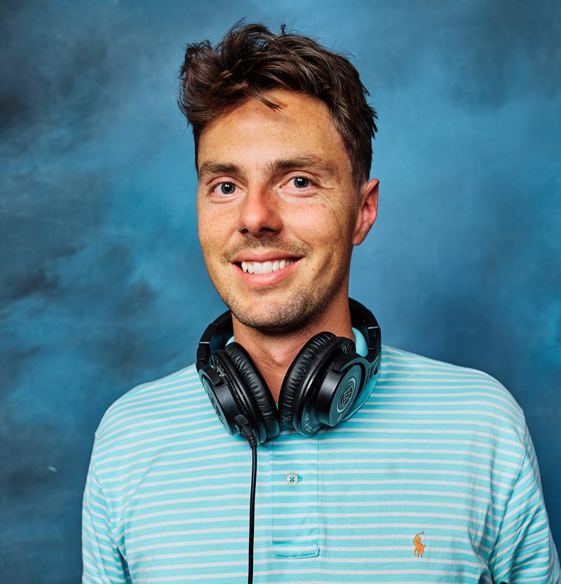 DJ Jon smiling with his headphones around his neck at the Access to Healthcare Network appreciation party