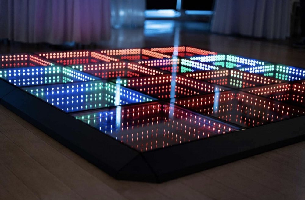 A close look at LED infinity dance floor panels lit red, blue and green, the lights seeming to sink deep into each panel