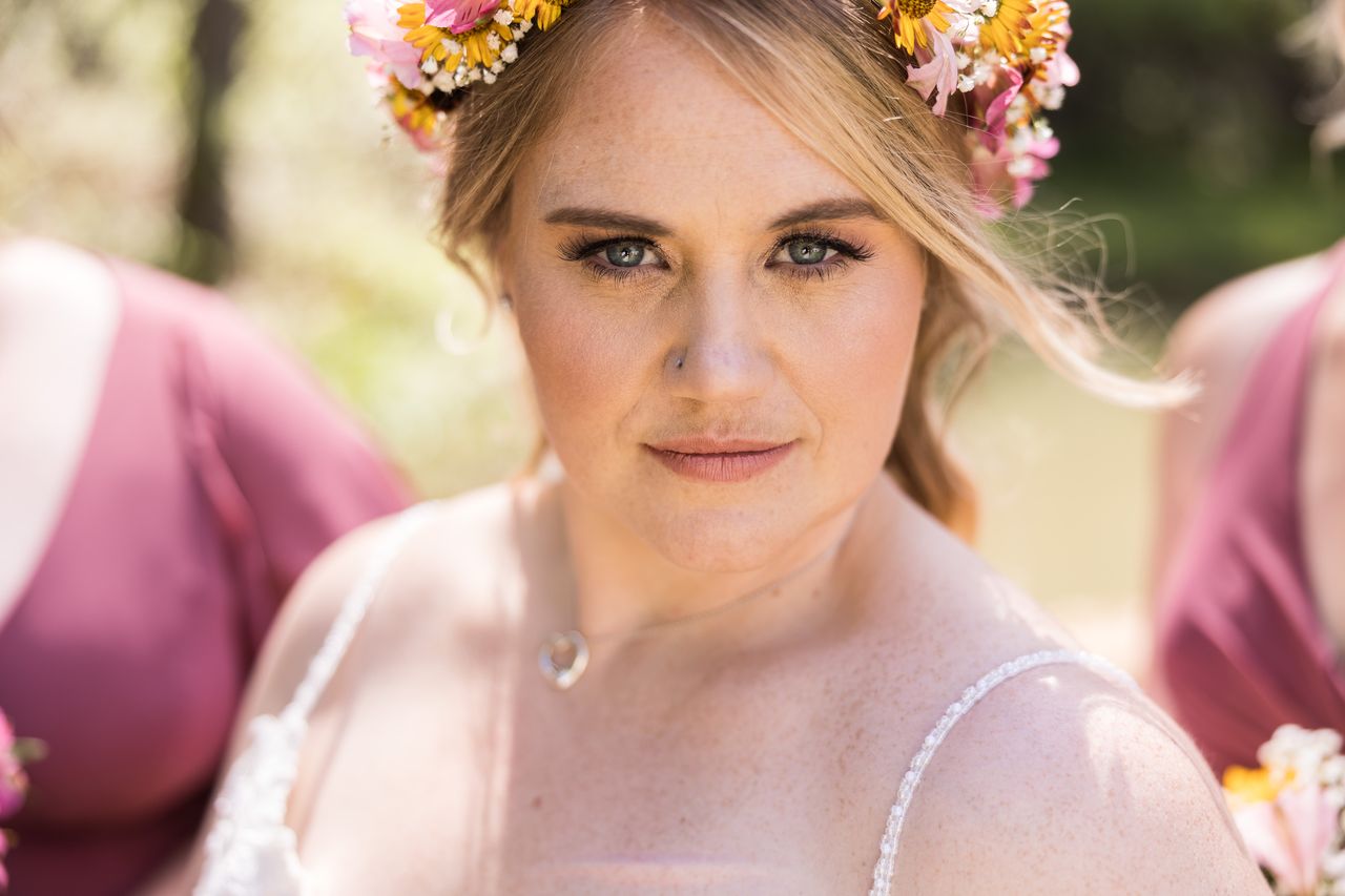 A close portrait of Abney in her flower crown, looking straight into the camera