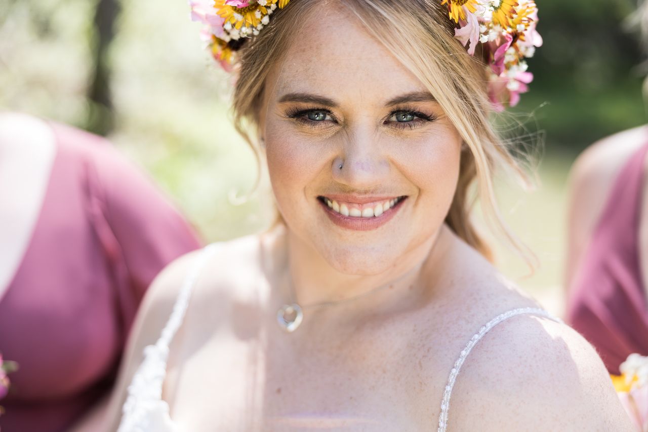 Abney smiles straight into the camera in a close portrait, her flower crown catching the light