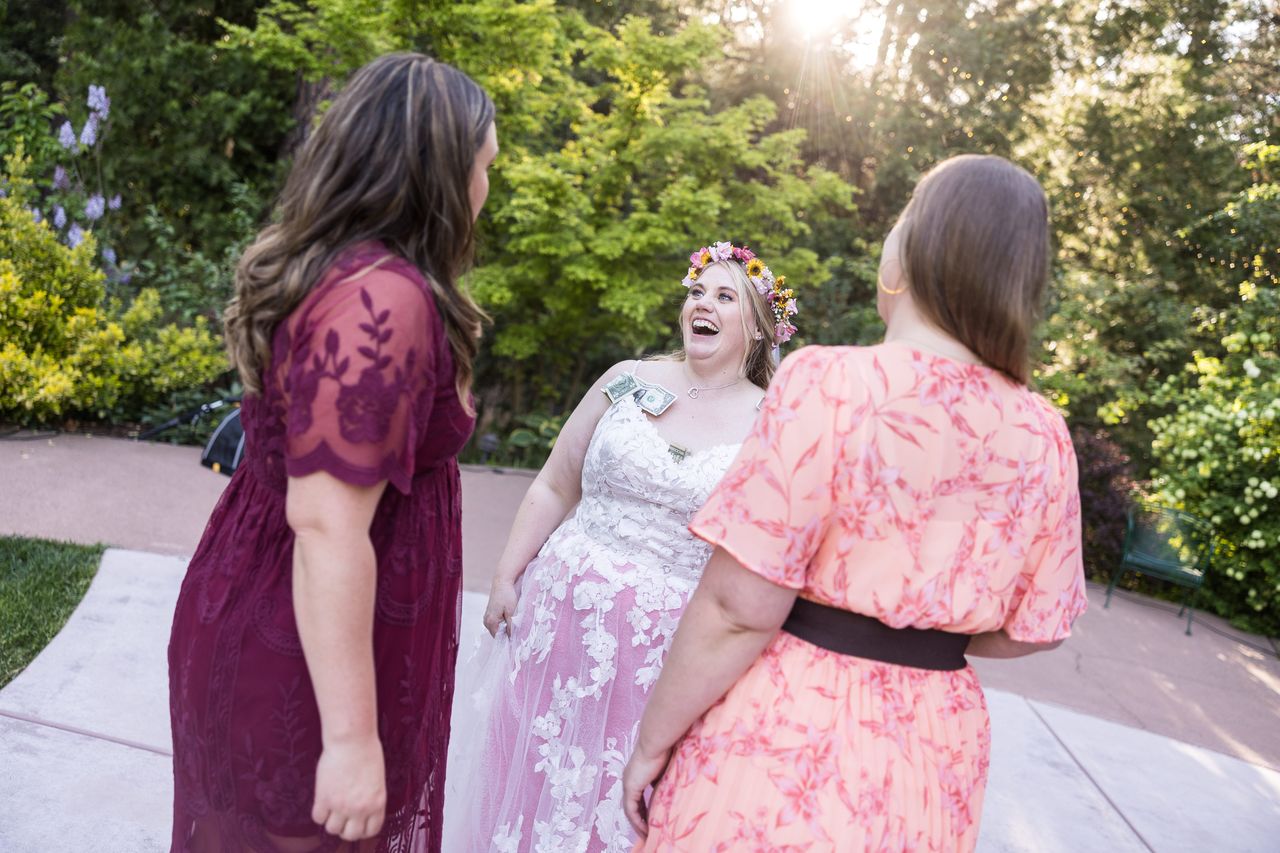 Abney laughs with two friends on the garden path as the evening sun comes through the trees