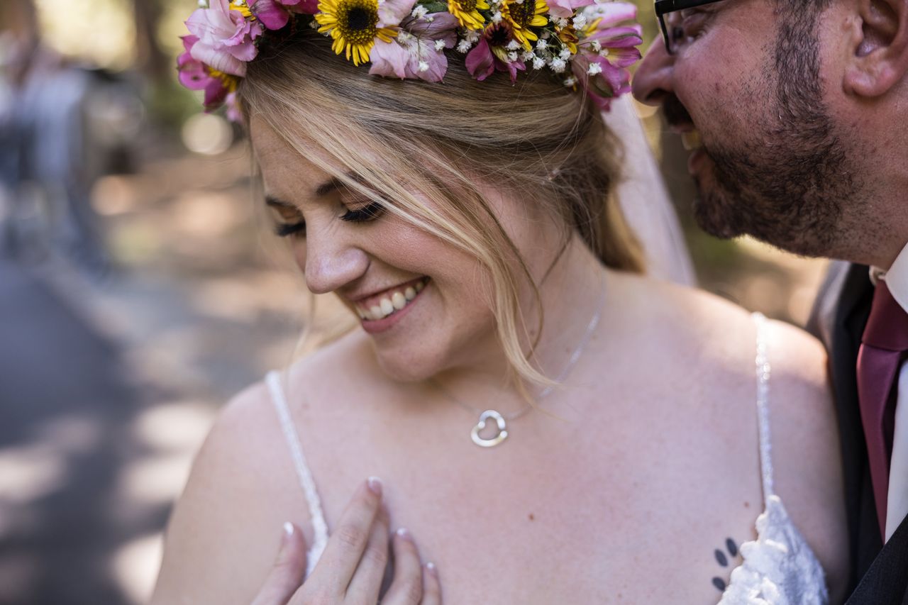 Abney smiles and looks down, her flower crown in focus, as Chris leans toward her