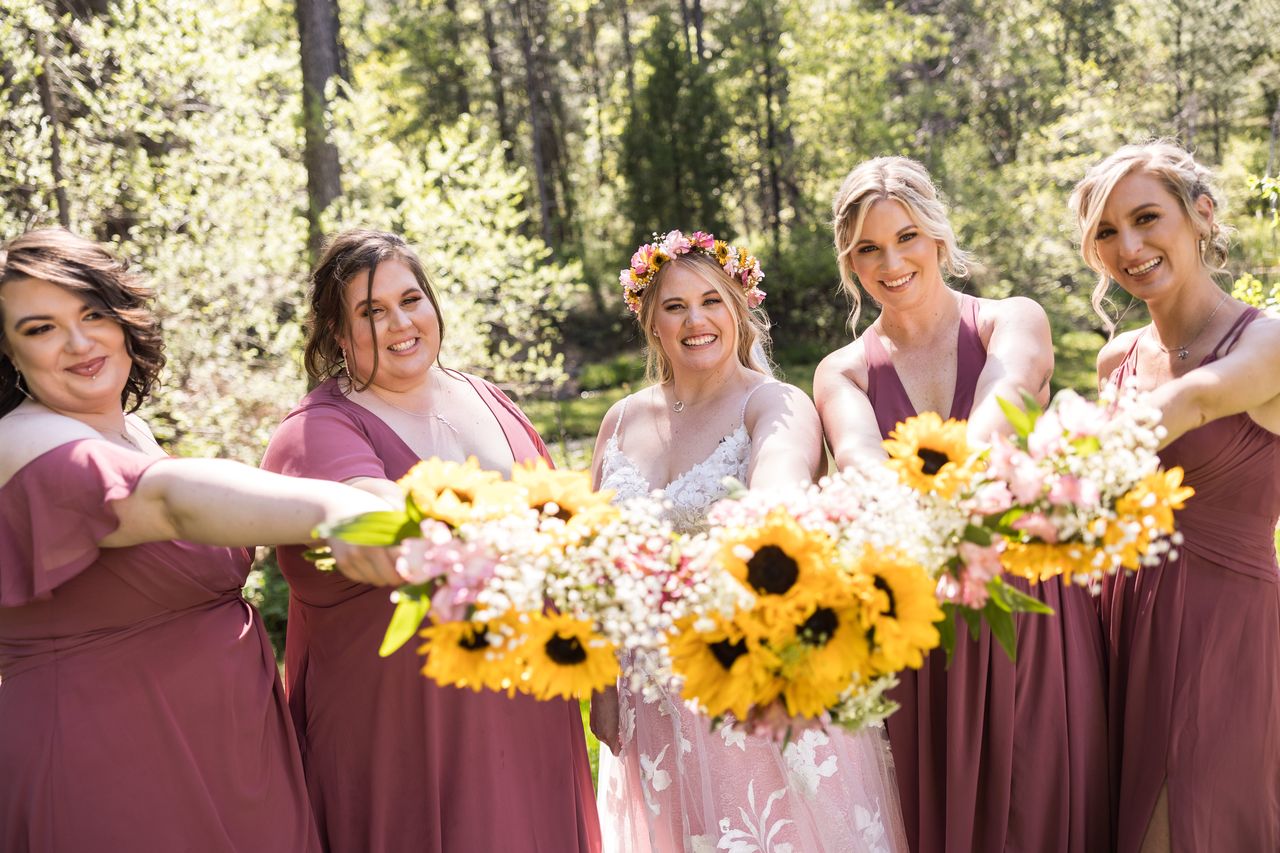 The sunflower bouquets held out in front of Abney and her bridesmaids
