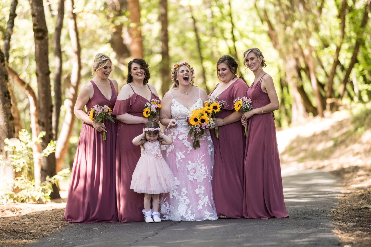 Abney, her bridesmaids and the flower girl stand together on a forest path