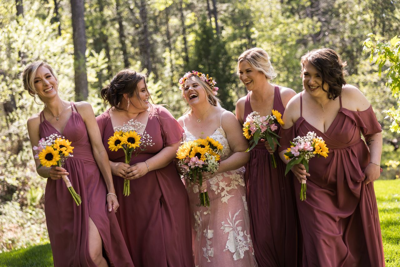 Abney and her bridesmaids laugh together as they walk across the grass