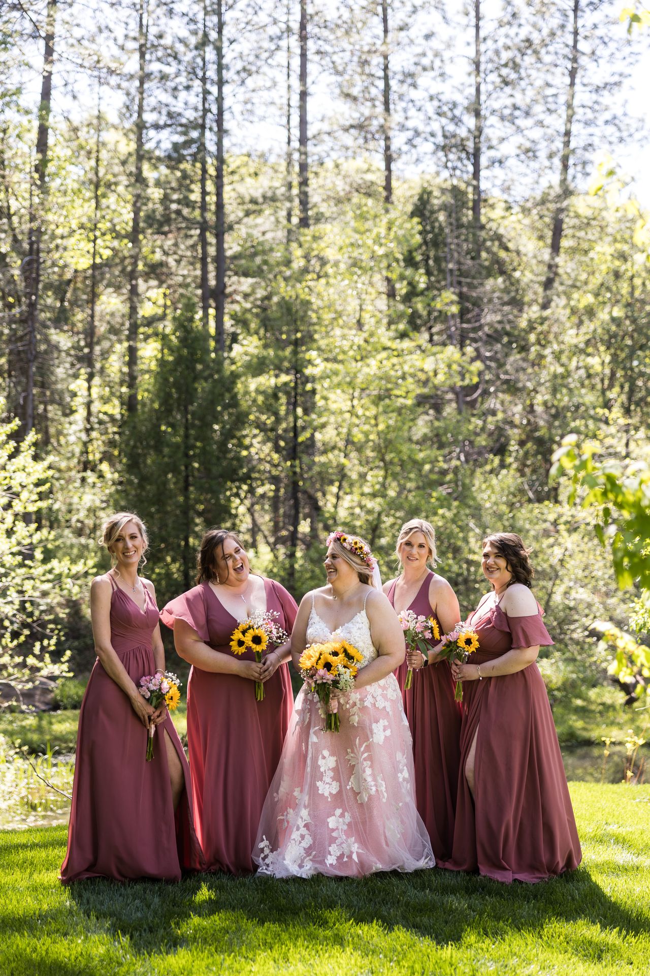 Abney and her four bridesmaids stand together on the lawn beneath the pines