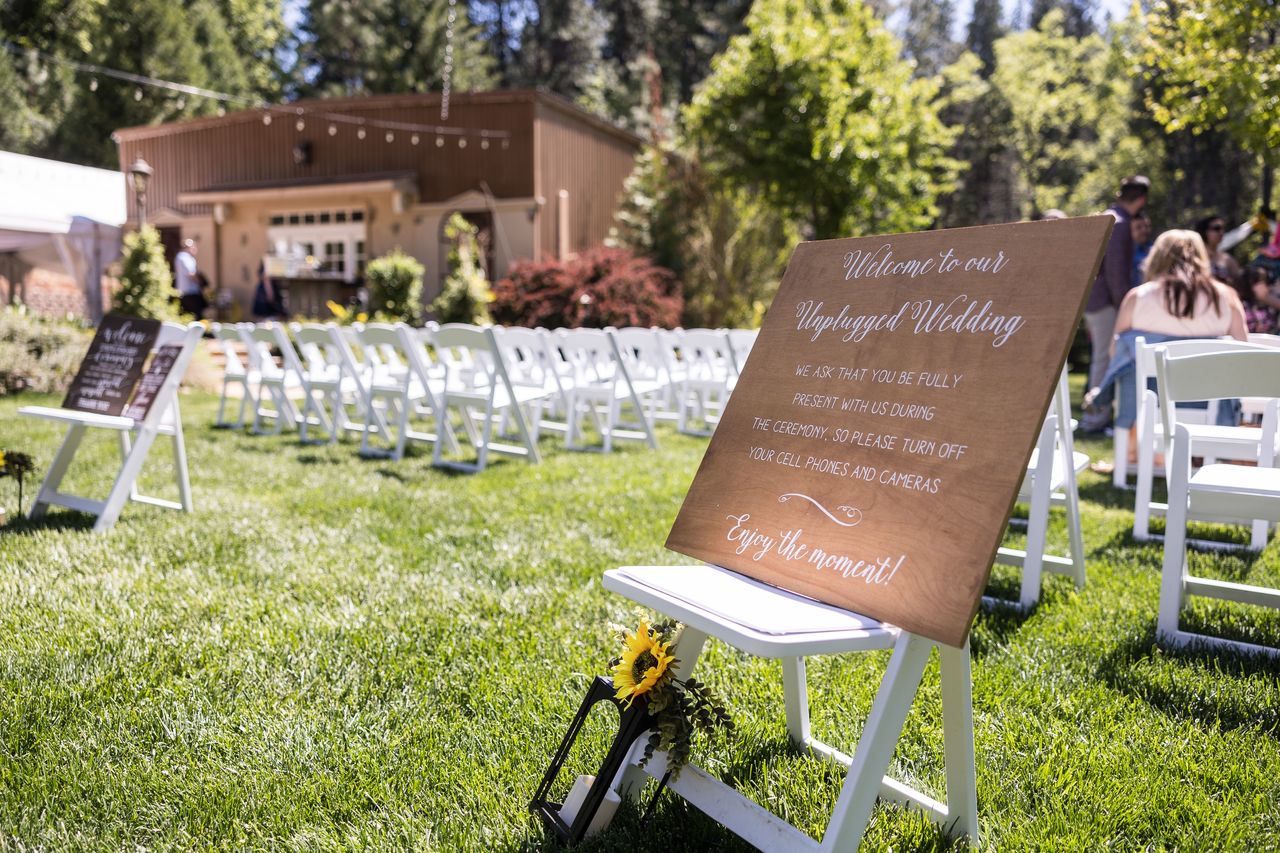 A wooden welcome sign beside rows of white chairs set for the ceremony
