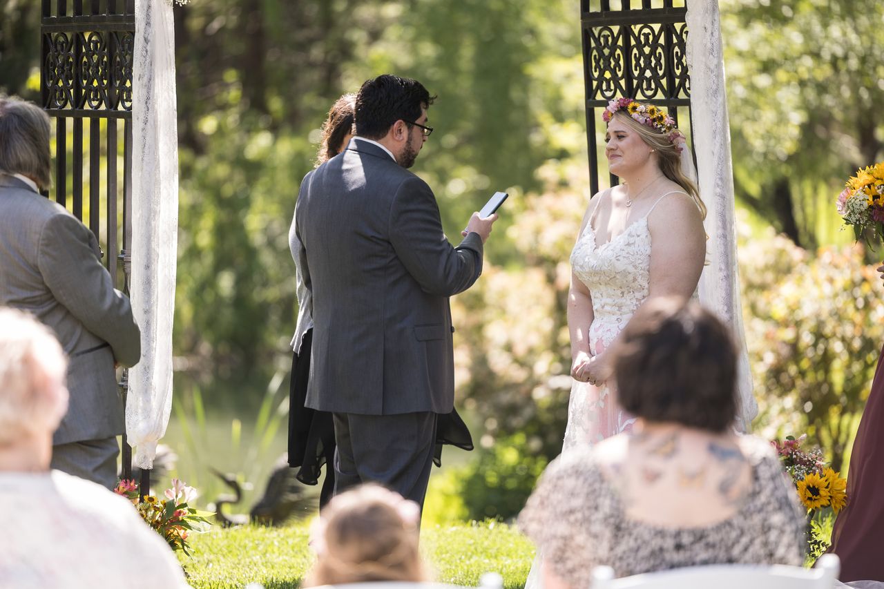 Chris reads his vows to Abney while guests watch from their seats