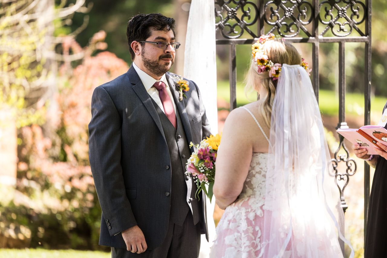 Chris looks at Abney as they stand at the arbor during the ceremony