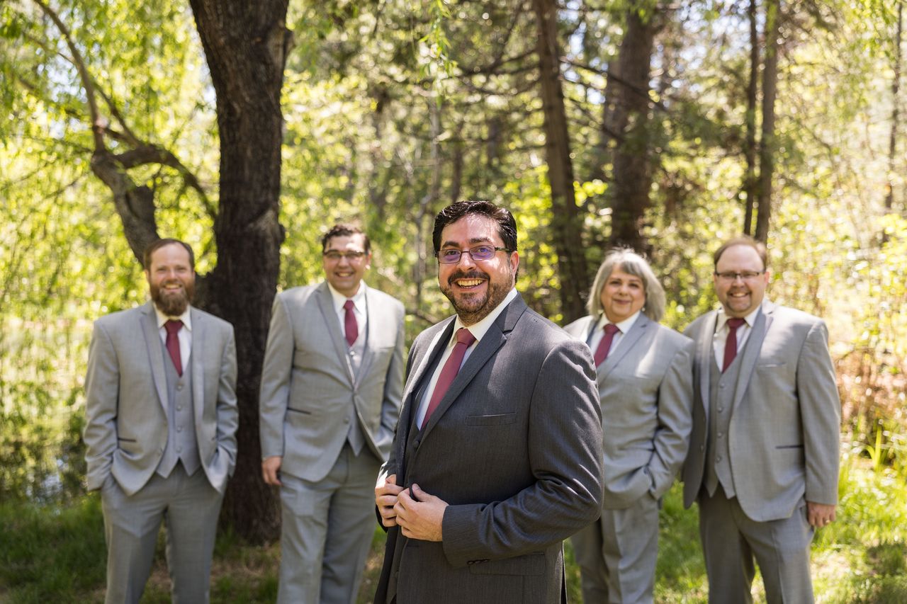 Chris stands with his wedding party, all in gray suits with burgundy ties