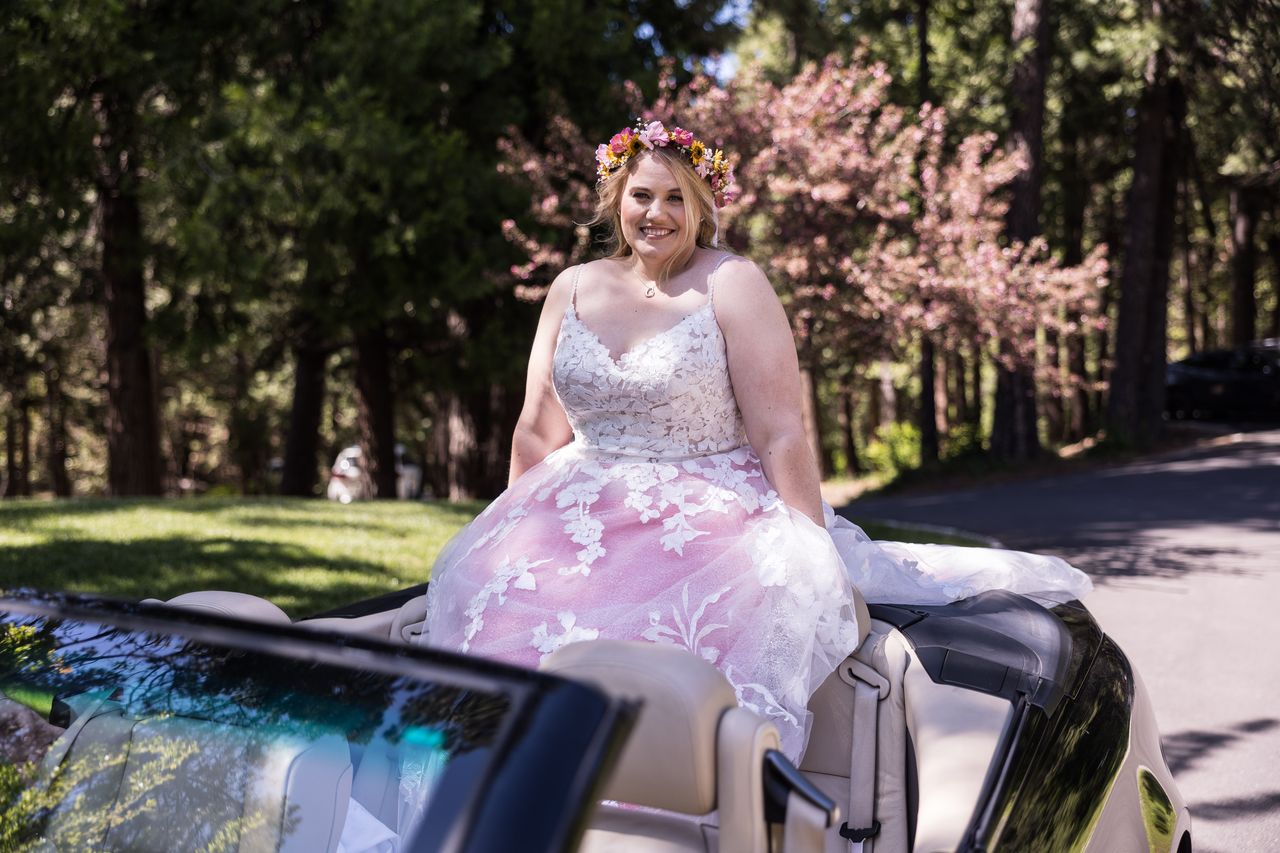 Abney smiles from the back of a convertible as she arrives for the ceremony