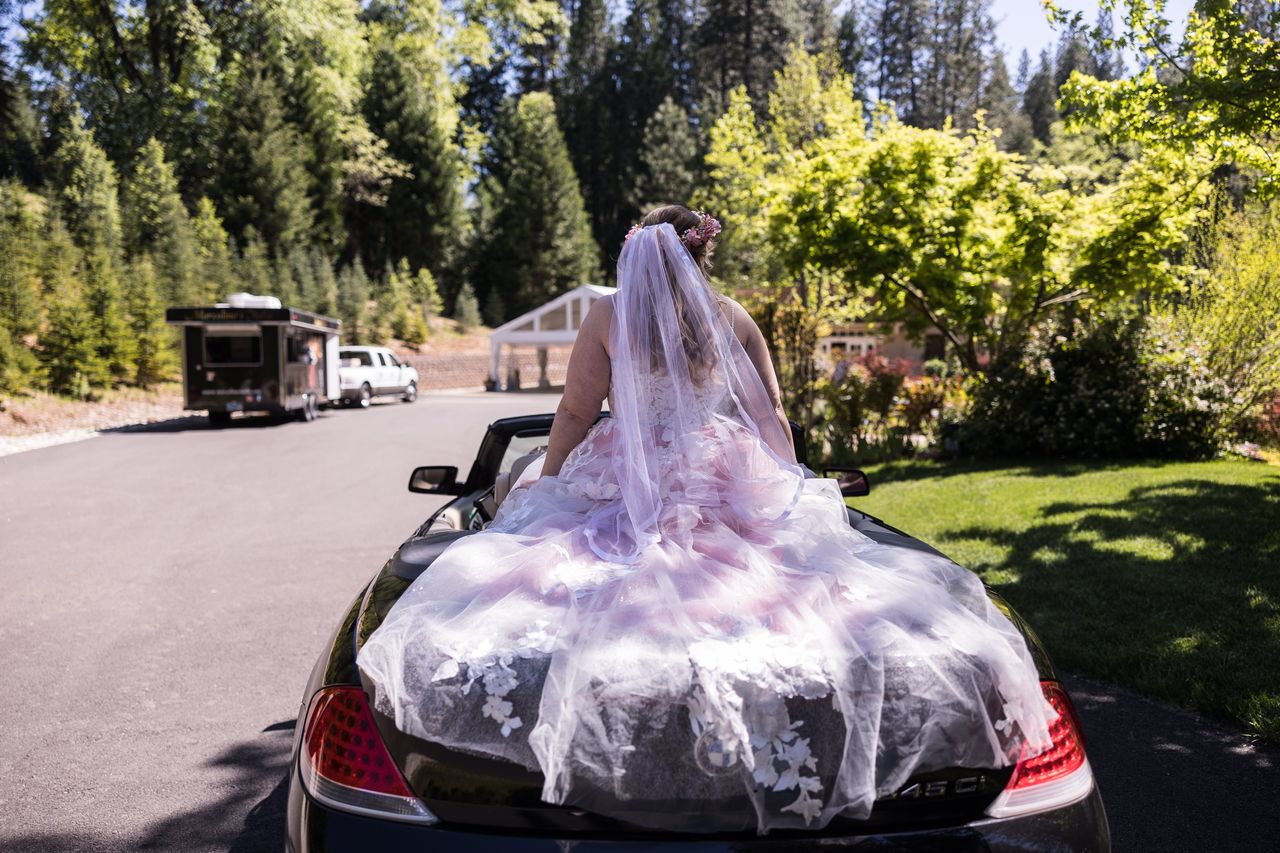Abney rides in on the back of a convertible, her veil trailing behind her