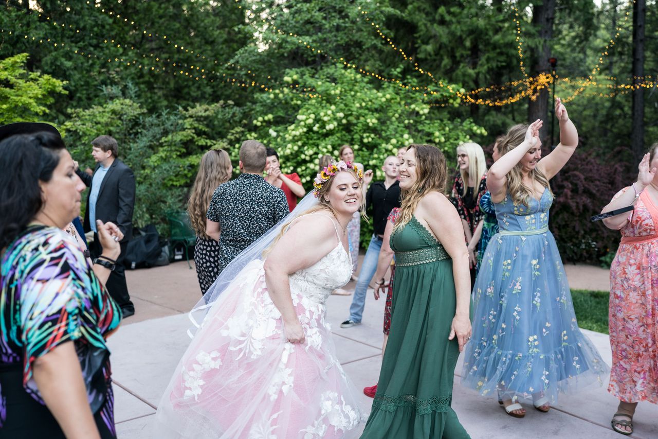 Abney smiles on the dance floor, surrounded by guests dancing under the string lights