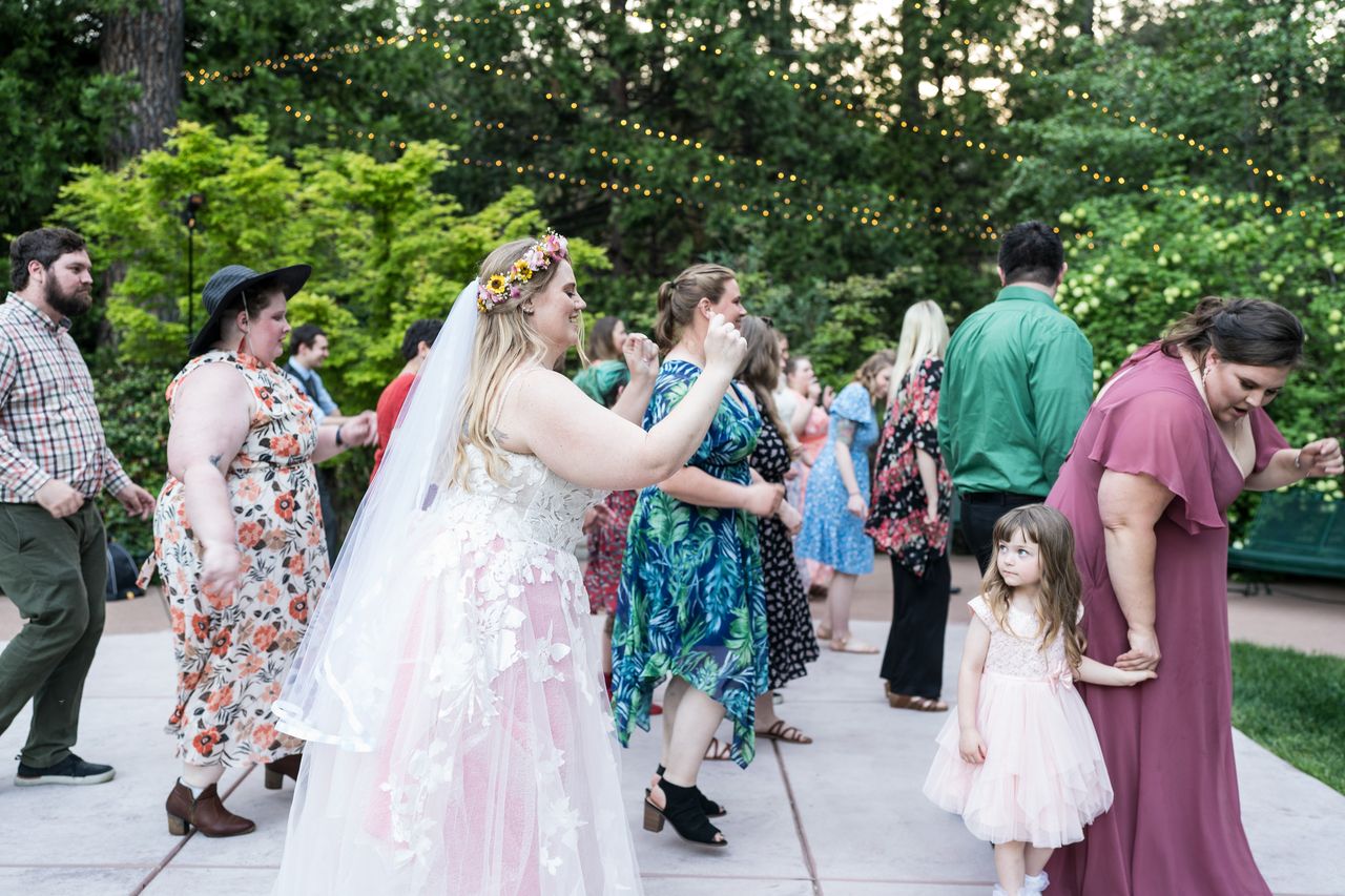 Abney claps along on a crowded dance floor while a little girl in a pink dress watches
