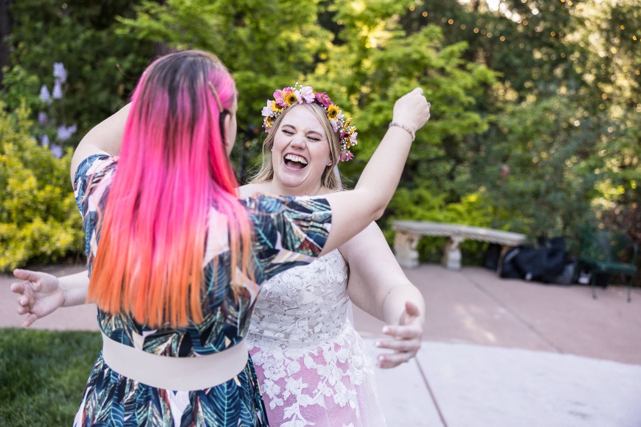 Abney dances with a guest who has bright pink and orange hair