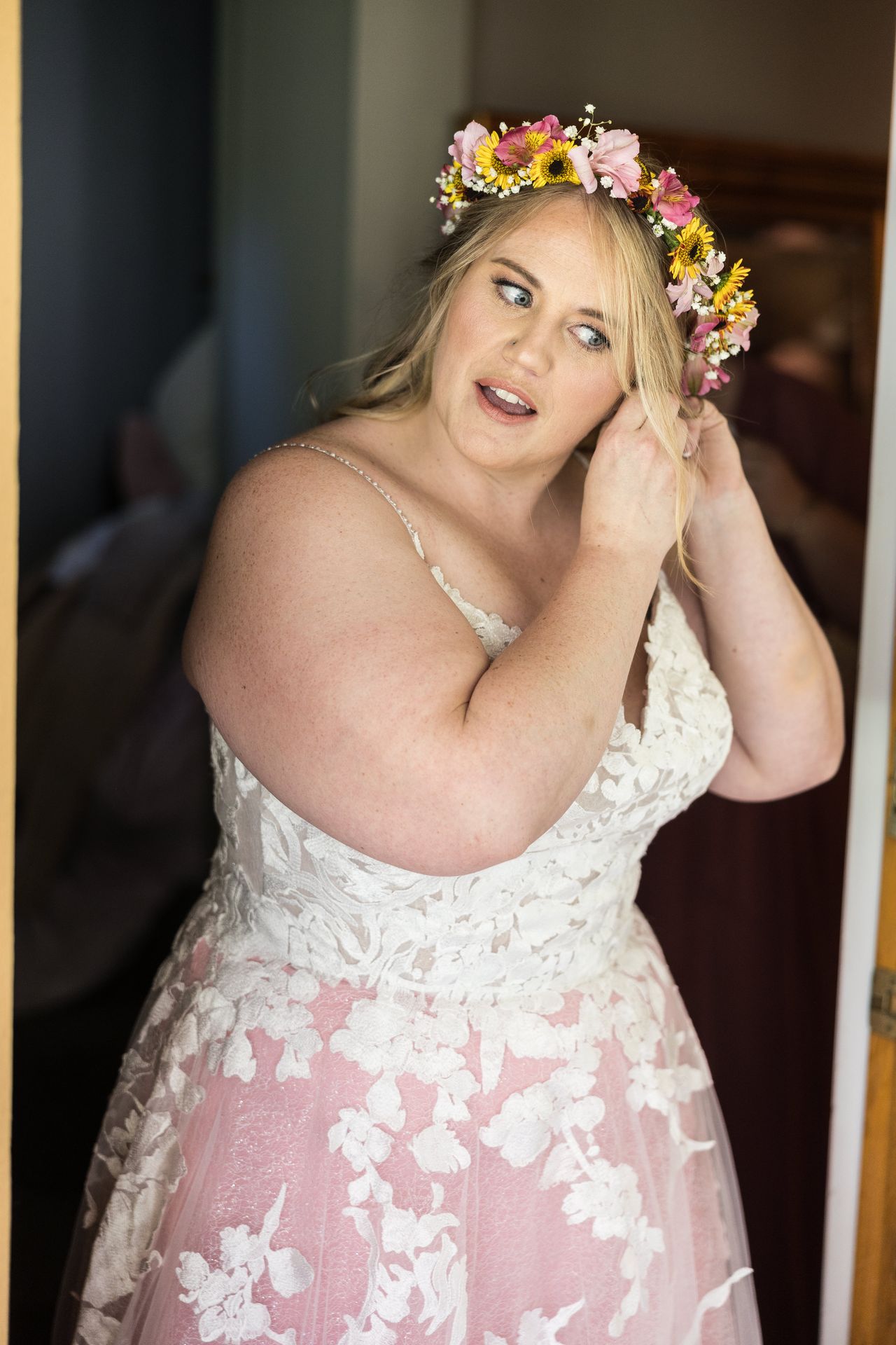 Abney stands in a doorway fastening an earring before the ceremony